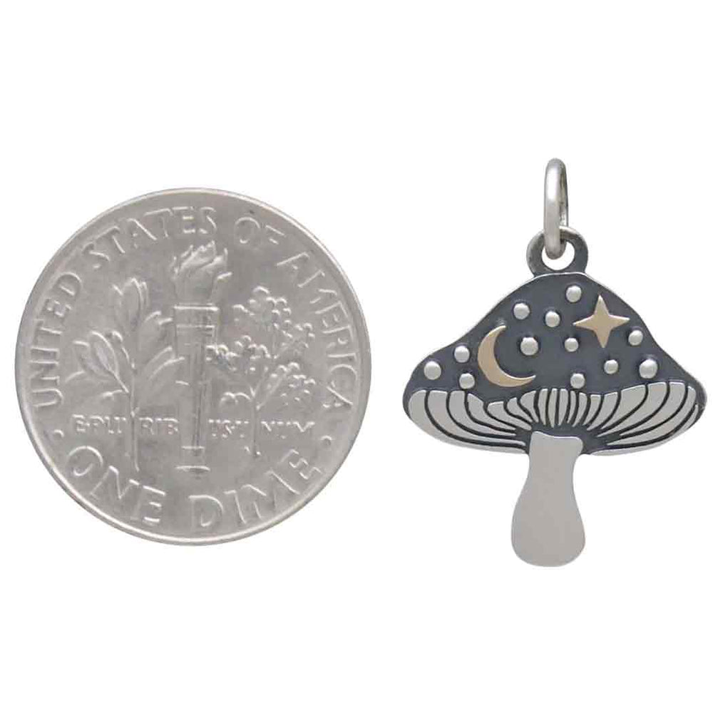A U.S. dime is shown next to the Nina Designs Silver Mushroom Charm with Bronze Star and Moon, highlighting the charm's size relative to the coin.