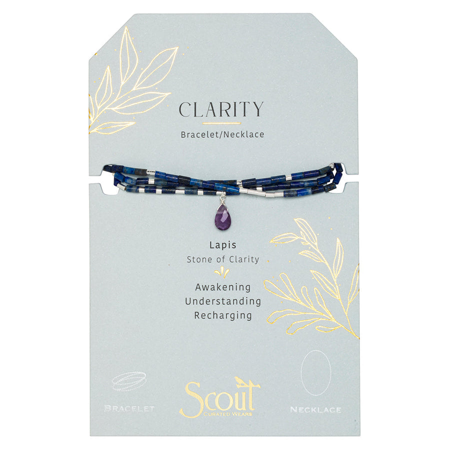 Scout Jewelry’s Clarity Lapis Silver Teardrop Wrap is a blue beaded necklace with a purple amethyst teardrop, displayed on a gray “CLARITY” card that highlights Lapis as the stone of clarity—awakening, understanding, and recharging.