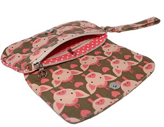 The Bungalow 360 Large Wristlet Pig features a pink pig and heart pattern, a pink interior with white polka dots, zipper compartment, and wrist strap—an eco-friendly purse for fans of playful, unique designs.