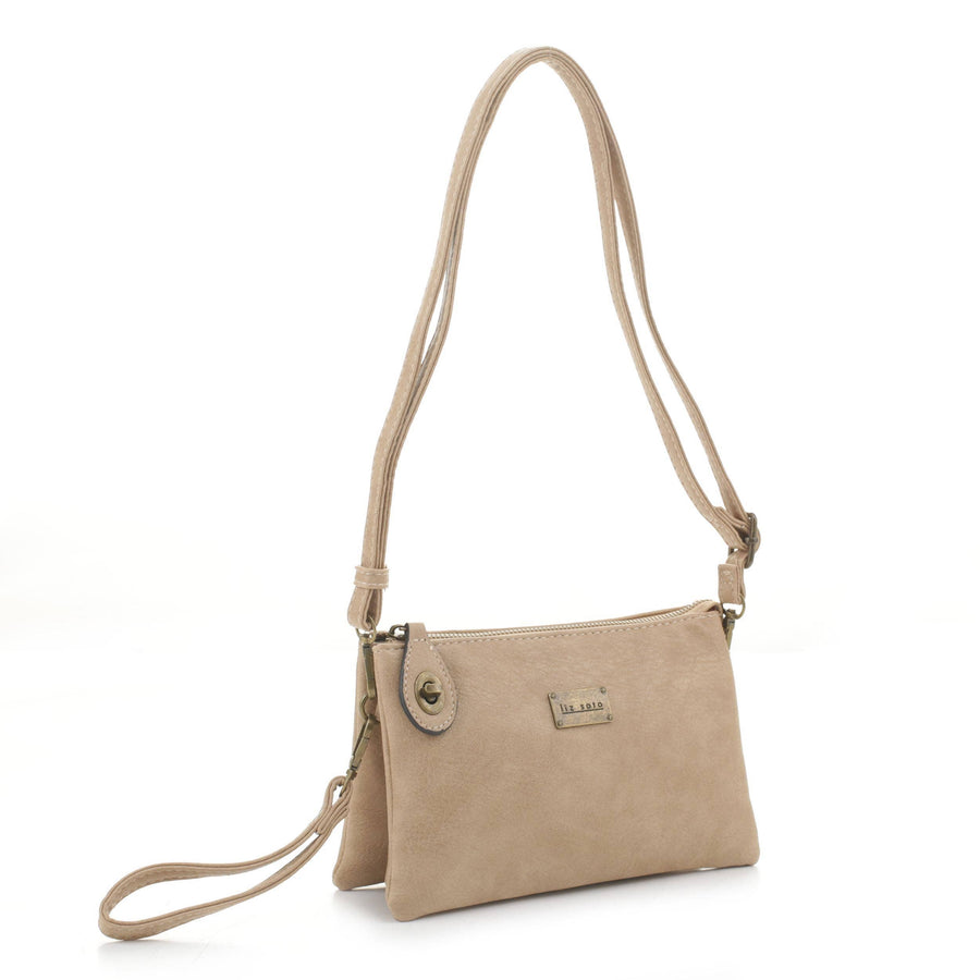 The Ella Crossbody - Almond by Liz Soto Handbags features a detachable strap for crossbody or wristlet use, gold hardware, zipper closure, and a rectangular logo plaque on the front, shown against a white background.
