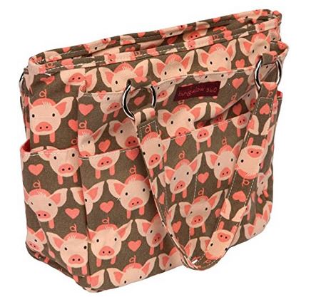 The Pocket Bag Pig by Bungalow 360 is a vegan tote featuring pink pig faces and hearts on brown, two shoulder straps, multiple external pockets, and a playful polka dot lining.
