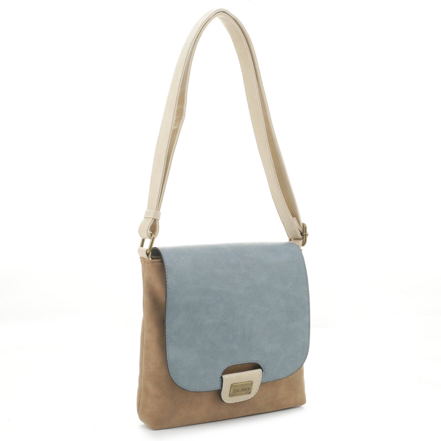 The Amy Crossbody - Denim by Liz Soto Handbags features a beige vegan leather body and strap, a light blue flap, and a rectangular metallic clasp. The adjustable strap adds comfort. Shown against a plain white background.