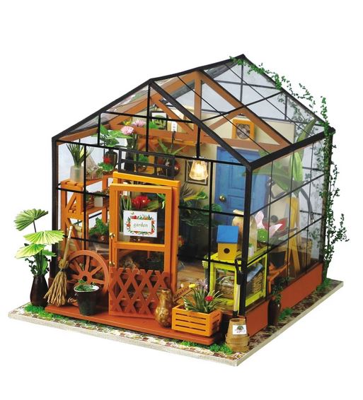 The Robotime Cathy’s Flower House DIY Miniature Kit features a transparent-roof greenhouse with tiny plants, gardening tools, furniture, and a welcome sign—ideal for any flower shop enthusiast.