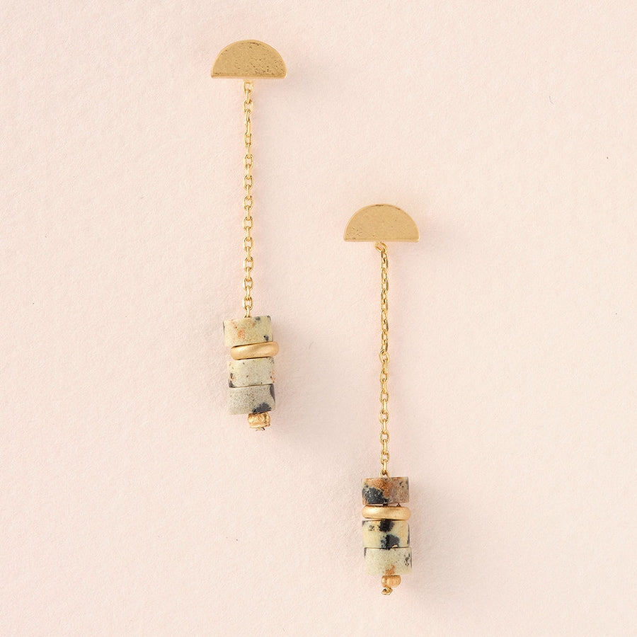 The Meteor Thread Dalmation Jasper Gold earrings by Scout Jewelry feature two gold half-circles connected by chains and cylindrical stone accents with marbled gold-banded stones. Made from nickel and cadmium-free materials, these hypoallergenic earrings guarantee elegance and comfort.