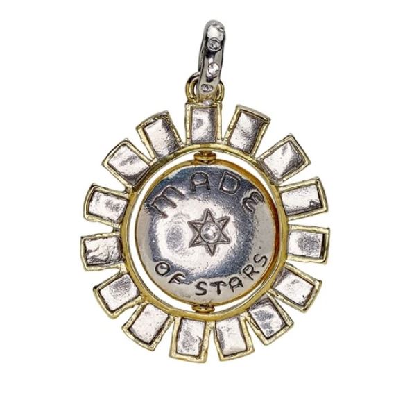 The Made of Stars Spinner Pendant by Waxing Poetic features a round brass sun with radiating spokes, a gold-tone edge, and an engraved "MADE OF STARS" center—an enchanting celestial accent for your crystal jewelry collection.