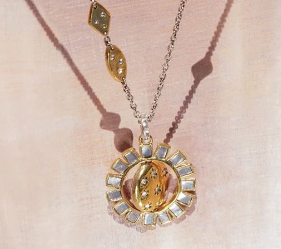 The Made of Stars Spinner Pendant by Waxing Poetic features gold and sterling silver with a sunburst design, embedded gemstones, and a shimmering look—ideal for fans of crystal jewelry.