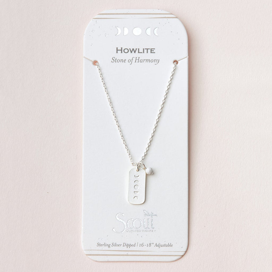 The Intention Neck Howlite/Silver necklace by Scout Jewelry features a silver rectangular pendant with moon phase symbols. It comes attached to a white card that reads "Howlite, Stone of Harmony." The engraved charm indicates that the necklace is sterling silver dipped and adjustable between 16-18 inches.