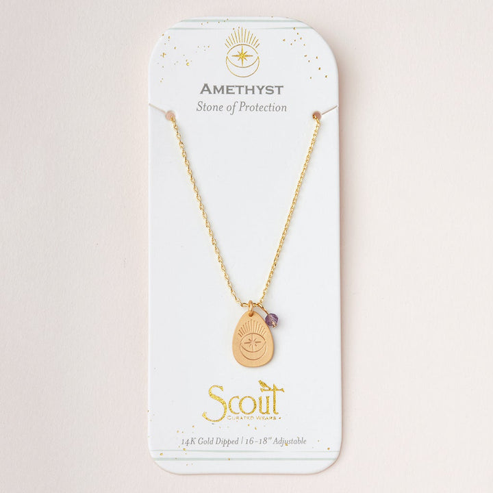An "Intention Neck Amethyst/Gold" necklace by Scout Jewelry, featuring a pendant with a small amethyst stone, is displayed on a white card. The card reads "AMETHYST - Stone of Protection" and "Scout," along with "14K Gold Dipped 16”-18” Adjustable Brass Chain" at the bottom, finished with decorative gold accents.