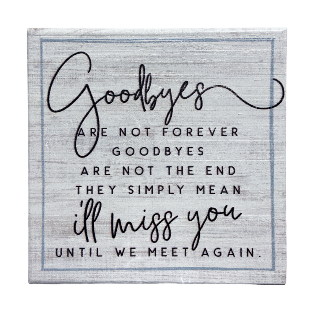 Introducing the "Goodbyes" sign by SincereSurroundings, a handcrafted decorative piece that beautifully conveys the heartfelt message: "Goodbyes are not forever. Goodbyes are not the end. They simply mean I'll miss you until we meet again." This charming sign is perfect for shelf displays, featuring a mix of cursive and bold fonts on a rustic white background to add warmth and character to any space.