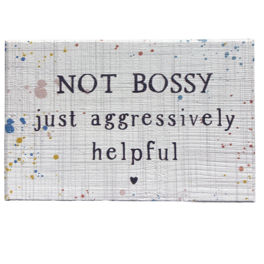 The "Not Bossy" sign by SincereSurroundings features a white wood texture adorned with colorful splatters, and displays the phrase "NOT BOSSY just aggressively helpful" with a small heart beneath the text. This delightful piece is perfect for easy display and adds a touch of whimsy to any space.