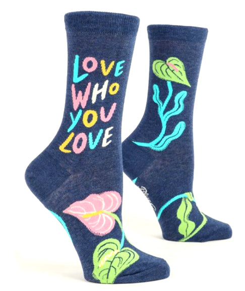 Blue Q’s Love Who You Love Socks are dark blue combed cotton, feature vibrant “LOVE WHO YOU LOVE” text and lively leaf designs in pink, green, and blue; fits women’s sock size 5-10.