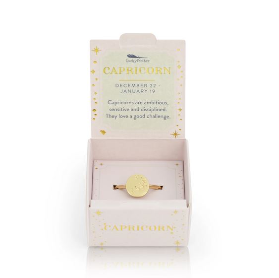 The LuckyFeather Capricorn Signet Ring is a 14k gold-dipped piece with a round, engraved Capricorn symbol, presented in a white and gold box featuring the words: ambitious, sensitive, disciplined, and loves a challenge.