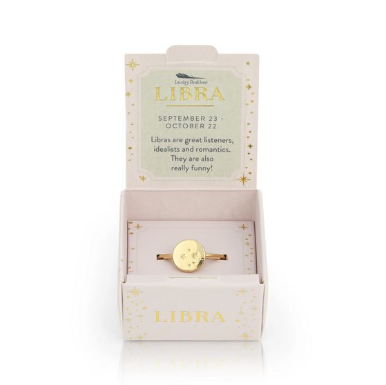 The LuckyFeather Libra Signet Ring, a 14k gold-dipped piece with a star design and adjustable band, is shown in an open box reading: "Libra. September 23 - October 22. Libras are great listeners, idealists and romantics.