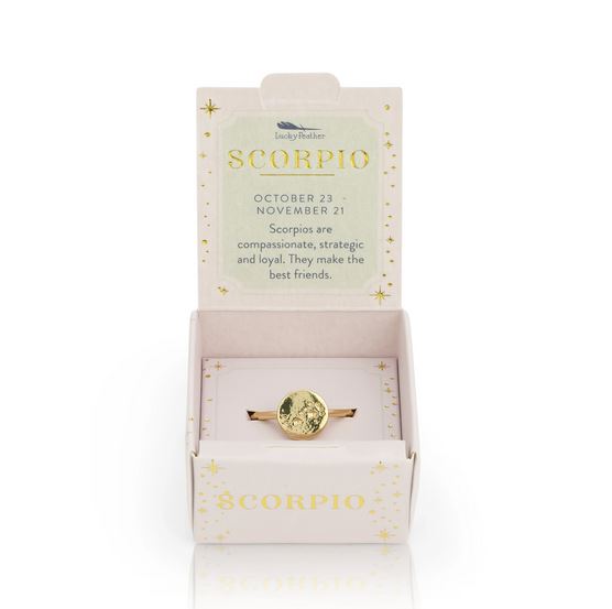 A LuckyFeather Scorpio Signet Ring with an adjustable gold-dipped band is shown in an open white box. On the lid: "SCORPIO October 23 - November 21. Scorpios are compassionate, strategic and loyal. They make the best friends.
